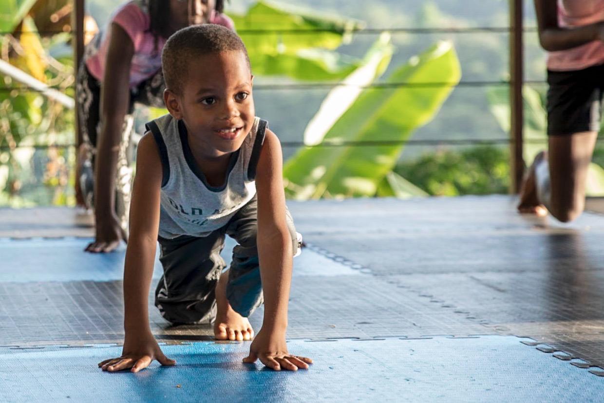 Close-up of a smiling child doing push-ups
