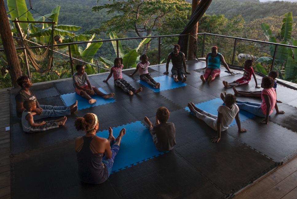 Children sitting in meditation circle with Eugene on the platform